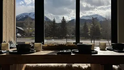 a table with a view of mountains from a window at Luxury modern, Central Ski, No stairs, EV! in Silverthorne