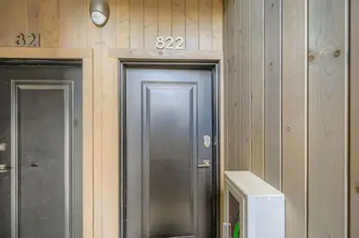two doors in a room with wooden walls and a microwave at River West 822 in Silverthorne