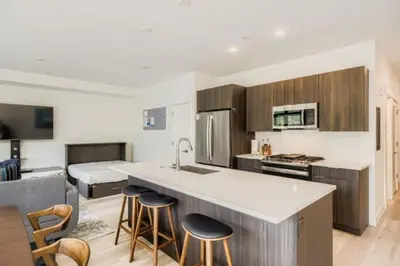 a kitchen with wooden cabinets and a kitchen island with bar stools at River West 822 in Silverthorne