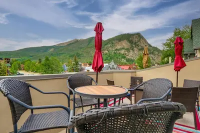 a table and chairs on a balcony with mountains at Patio with Peak 1 Mtn View Main Street Frisco Condo in Frisco