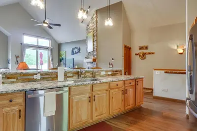 a large kitchen with wooden cabinets and stainless steel appliances at Patio with Peak 1 Mtn View Main Street Frisco Condo in Frisco