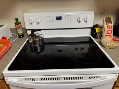 a white stove top oven with a pot on it at Condo 2BR on Winter Park Ski Bus Route for Christmas in Fraser