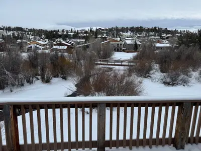 a snow covered deck with a view of a city at Condo 2BR on Winter Park Ski Bus Route for Christmas in Fraser