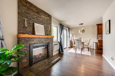 a living room with a brick fireplace and a dining room at 2 Mi to CU Boulder Mtn-View Condo with Pool Access in Boulder