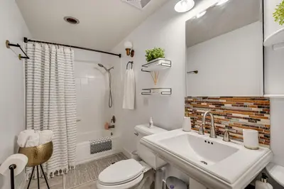 a white bathroom with a sink and a toilet at 2 Mi to CU Boulder Mtn-View Condo with Pool Access in Boulder