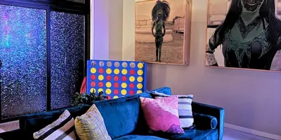a blue couch with colorful pillows in a living room at Artful Stay, Downtown, Spacious, LED Art, Hot Tub in Denver