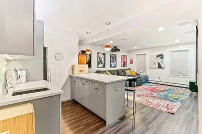 an open kitchen and living room with a couch at Artful Stay, Downtown, Spacious, LED Art, Hot Tub in Denver