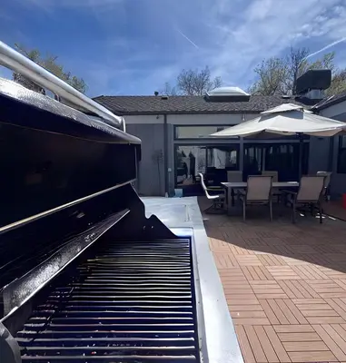 an outdoor patio with a piano and a table and umbrella at Artful Stay, Downtown, Spacious, LED Art, Hot Tub in Denver