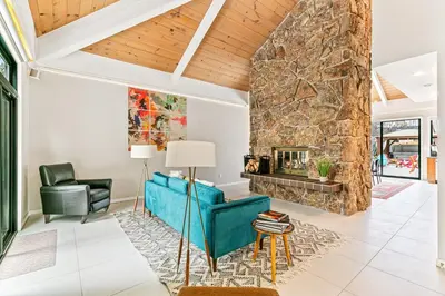 a living room with a blue couch and a stone fireplace at Artful Stay, Downtown, Spacious, LED Art, Hot Tub in Denver