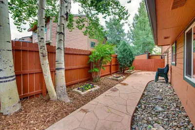 a backyard with a fence and a bench and trees at Walk to Ski Shuttle Dtwn Frisco Gem with Fireplace! in Frisco