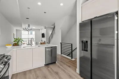 a kitchen with white cabinets and stainless steel appliances at 3534 W 63rd Ave in Denver