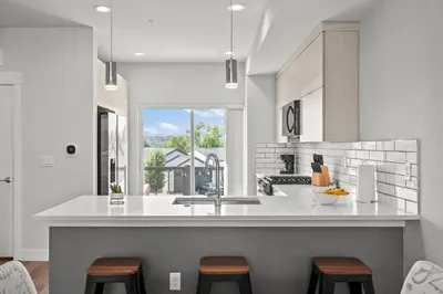 a kitchen with a sink and a counter with stools at 3534 W 63rd Ave in Denver