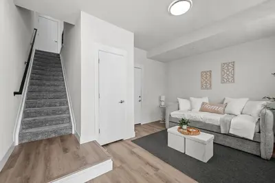 a living room with a couch and a staircase at 3534 W 63rd Ave in Denver