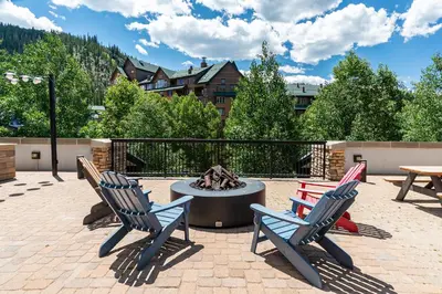 a patio with two chairs and a fire pit at Platinum Top Floor Ski-in Ski-out WP Resort in Winter Park
