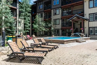 a group of chairs sitting next to a swimming pool at Platinum Top Floor Ski-in Ski-out WP Resort in Winter Park