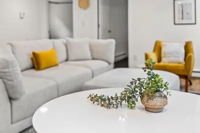 a living room with a white table with a plant on it at 5280 Oasis - Hot Tub Walk to Sloan's Lake in Denver