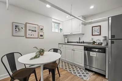 a kitchen with a white table and chairs and a refrigerator at 5280 Oasis - Hot Tub Walk to Sloan's Lake in Denver