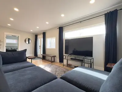 a living room with two couches and a large screen tv at NEW REMODEL Denver Luxury Home with Private HOT TUB in Denver