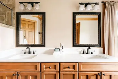 two sinks in a bathroom with two mirrors at Ski Hike Relax - Log Cabin with Views - Hot tub in Silverthorne