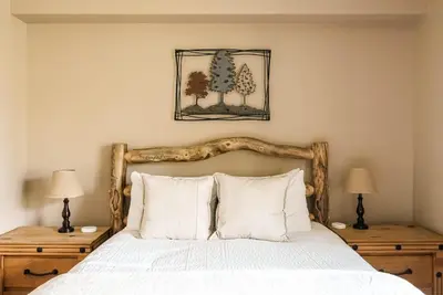 a bedroom with a bed with white sheets and two lamps at Ski Hike Relax - Log Cabin with Views - Hot tub in Silverthorne