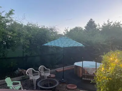 an umbrella in a yard with chairs and a tub at Sunny and Spacious, Hottub, Piano, Guitars, Fenced Yard, Pets Welcome, LGBT Friendly in Westminster