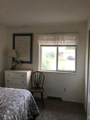 a bedroom with a bed and a chair and a window at Sunny and Spacious, Hottub, Piano, Guitars, Fenced Yard, Pets Welcome, LGBT Friendly in Westminster