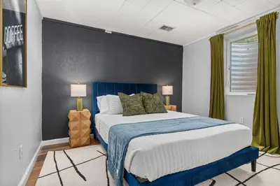 a bedroom with a large bed with a blue headboard at 6BR Family Retreat with Games Billiards Mini Golf BBQ and Yard in Westminster