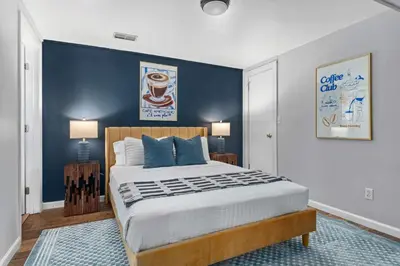 a bedroom with a large bed with a blue wall at 6BR Family Retreat with Games Billiards Mini Golf BBQ and Yard in Westminster