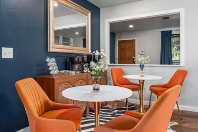 a waiting room with two tables and orange chairs at 6BR Family Retreat with Games Billiards Mini Golf BBQ and Yard in Westminster