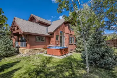 a log home with a hot tub in the yard at Highland Greens 42 in Breckenridge