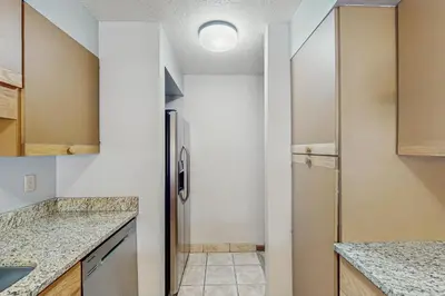 a kitchen with white walls and a refrigerator at Quicksilver 1654 in Keystone