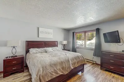 a bedroom with a bed and a flat screen tv at Quicksilver 1654 in Keystone