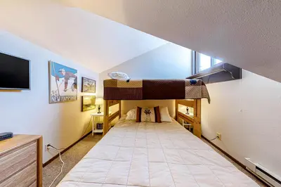 a room with two bunk beds and a tv at Flying Dutchman 1202 in Keystone
