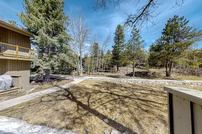 a house with a fence and a yard with trees at Flying Dutchman 1202 in Keystone