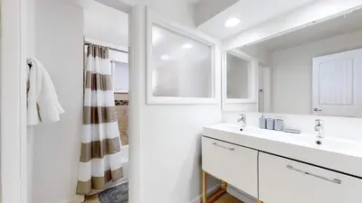 a white bathroom with a sink and a shower at Wild West-Inspired Family Home in Denver