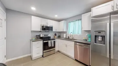 a kitchen with white cabinets and stainless steel appliances at Unique Family Home in Denver in Denver