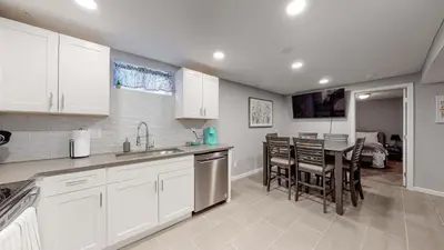 a kitchen with white cabinets and a table and chairs at Unique Family Home in Denver in Denver