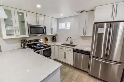 a kitchen with white cabinets and stainless steel appliances at Entire Family Home in Denver in Denver