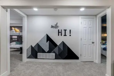 a room with a wall with a mural of a mountain at Mile Hi Basecamp Hot tub and Game Room in Denver