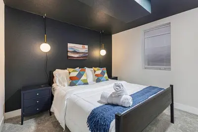 a bedroom with a bed with a towel on it at Mile Hi Basecamp Hot tub and Game Room in Denver