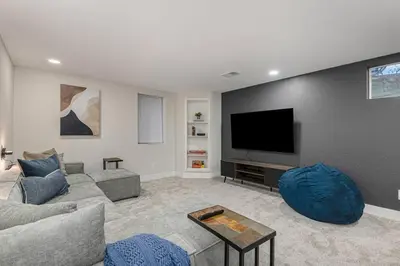 a living room with a couch and a flat screen tv at Mile Hi Basecamp Hot tub and Game Room in Denver
