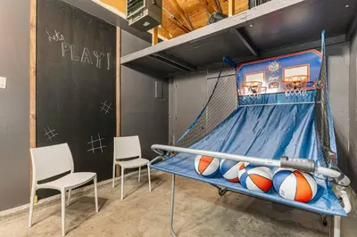 a basketball hoop with two chairs and balls on it at Mile Hi Basecamp Hot tub and Game Room in Denver