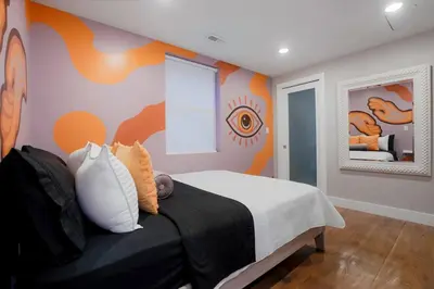 a bedroom with a bed with a painting on the wall at Good Vibe Tribe-2 Mi DT-Hot Tub-K Bed-Pet Friendly in Denver