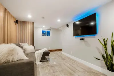 a living room with a couch and a flat screen tv at Good Vibe Tribe-2 Mi DT-Hot Tub-K Bed-Pet Friendly in Denver