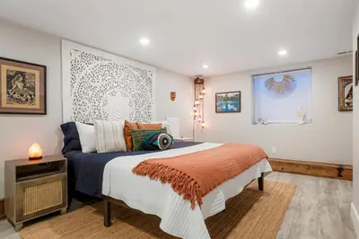 a bedroom with a large bed and a table at Good Vibe Tribe-2 Mi DT-Hot Tub-K Bed-Pet Friendly in Denver