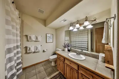 a bathroom with a sink and a toilet and a mirror at Mountain Bliss 3 BR Retreat With Views and Hot Tub in Tabernash