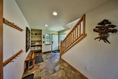 a living room with stairs and a wooden table at Mountain Bliss 3 BR Retreat With Views and Hot Tub in Tabernash