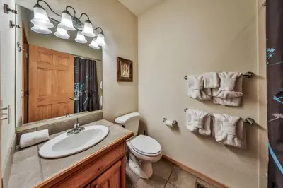 a bathroom with a sink and a toilet and a mirror at Mountain Bliss 3 BR Retreat With Views and Hot Tub in Tabernash