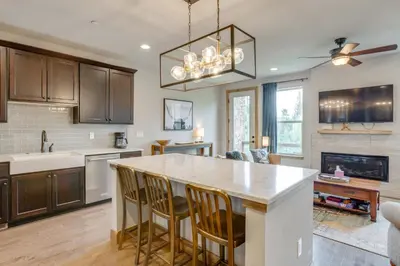a kitchen with a large island with bar chairs at 2 Mi to Fraser River Trail Townhome with Hot Tub! in Fraser