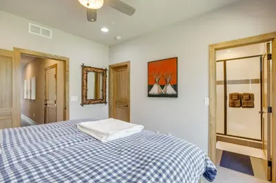 a bedroom with a bed with a blue and white checkered blanket at 2 Mi to Fraser River Trail Townhome with Hot Tub! in Fraser
